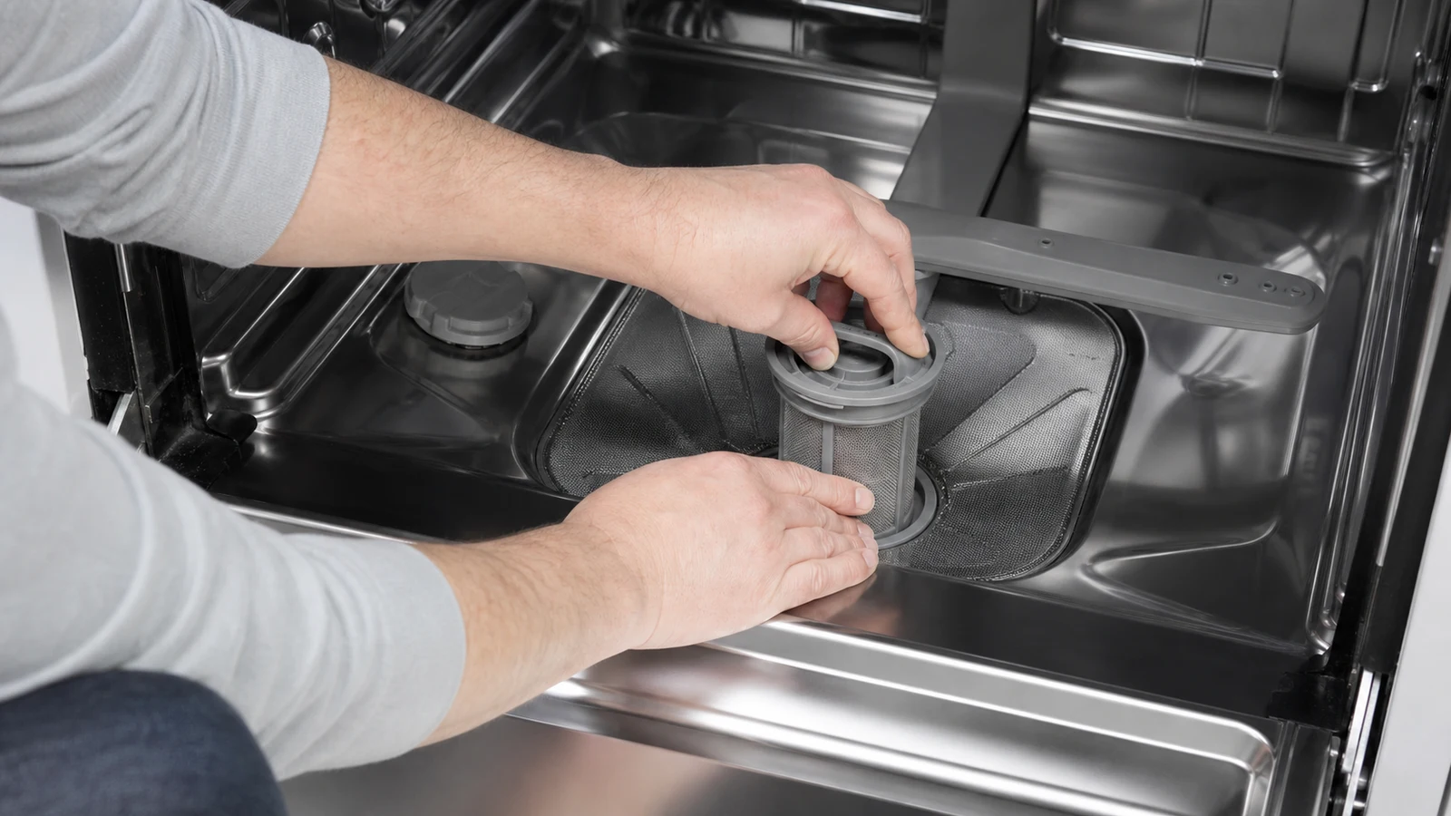 Filter basket being rotated clockwise back into the dishwasher cavity until it locks into position