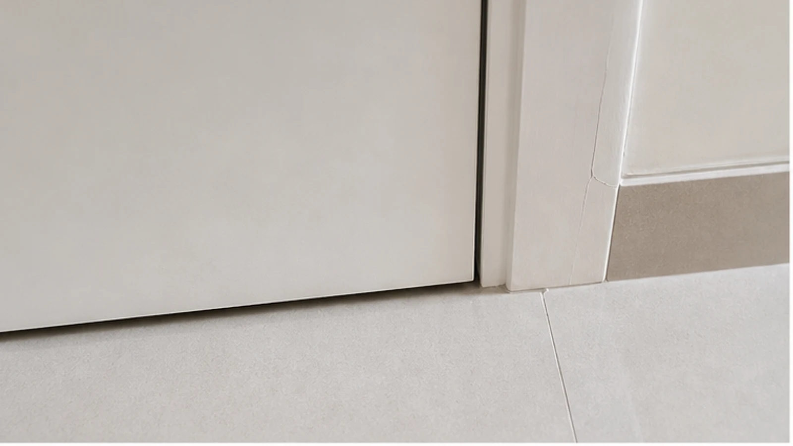 Wide view of a door frame showing an uneven gap between the door and frame on one side, indicating frame movement.