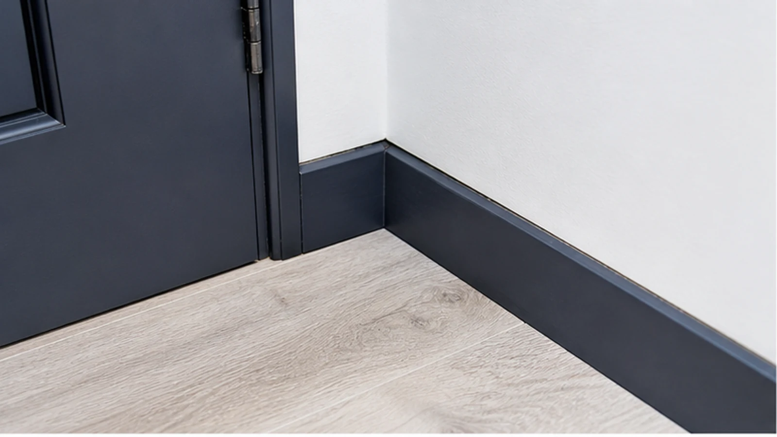 An ordinary baseboard gap being visually checked without applying sealant or opening services.