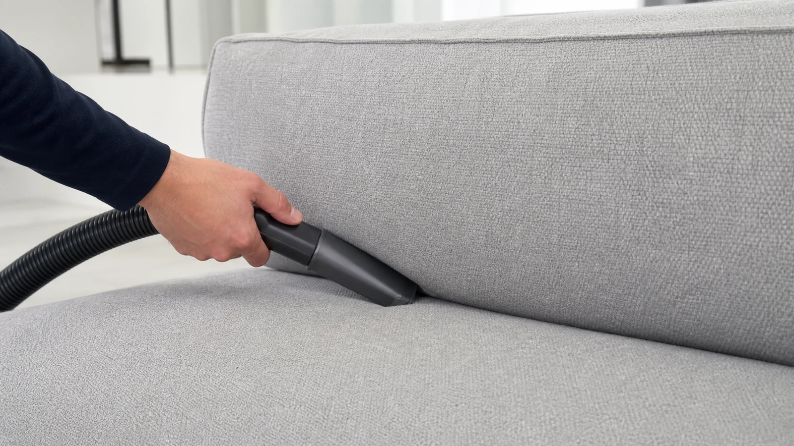 A clean non-rotary upholstery attachment hidden-tested on dry sofa fabric.