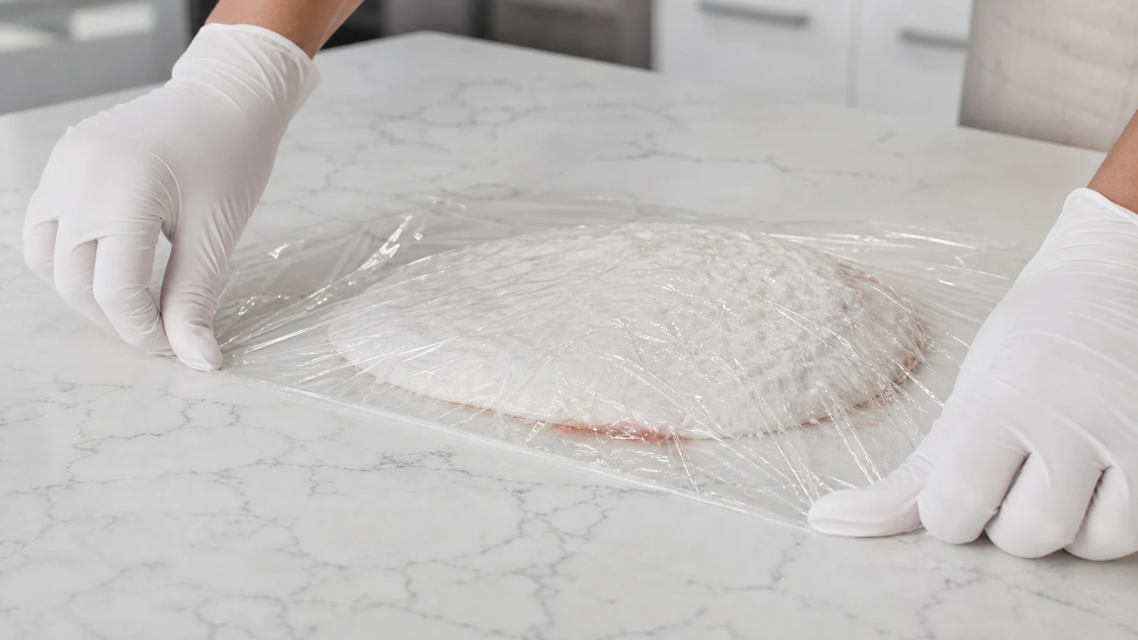 Gloved hands position the exact covering material required by a documented poultice method.