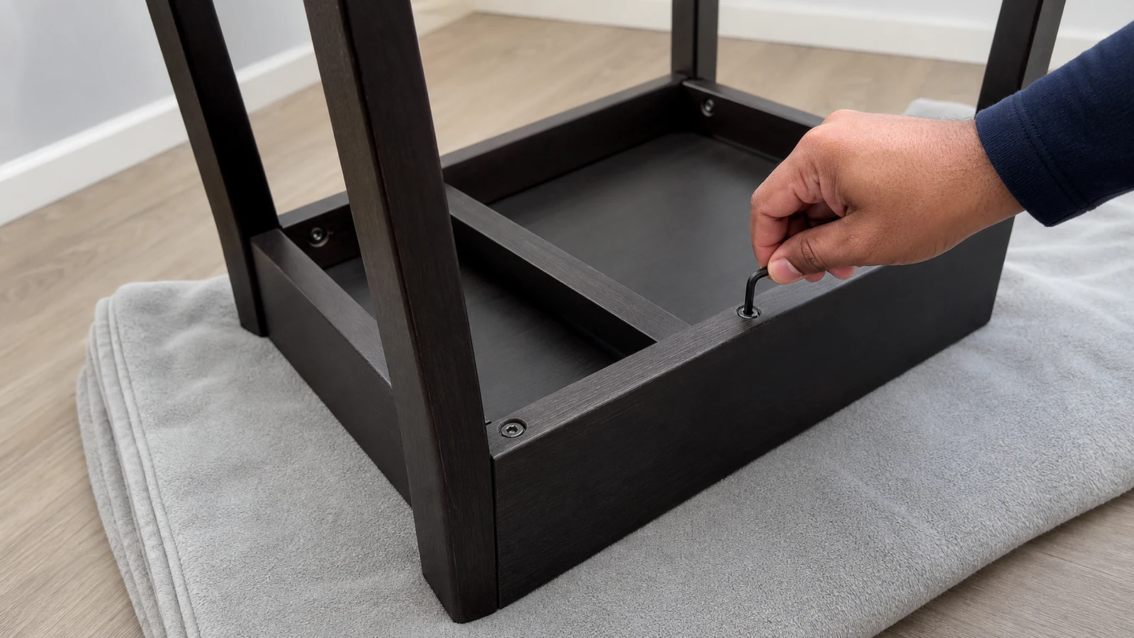 Upturned chair with multiple fasteners partially visible, showing a systematic approach to tightening.